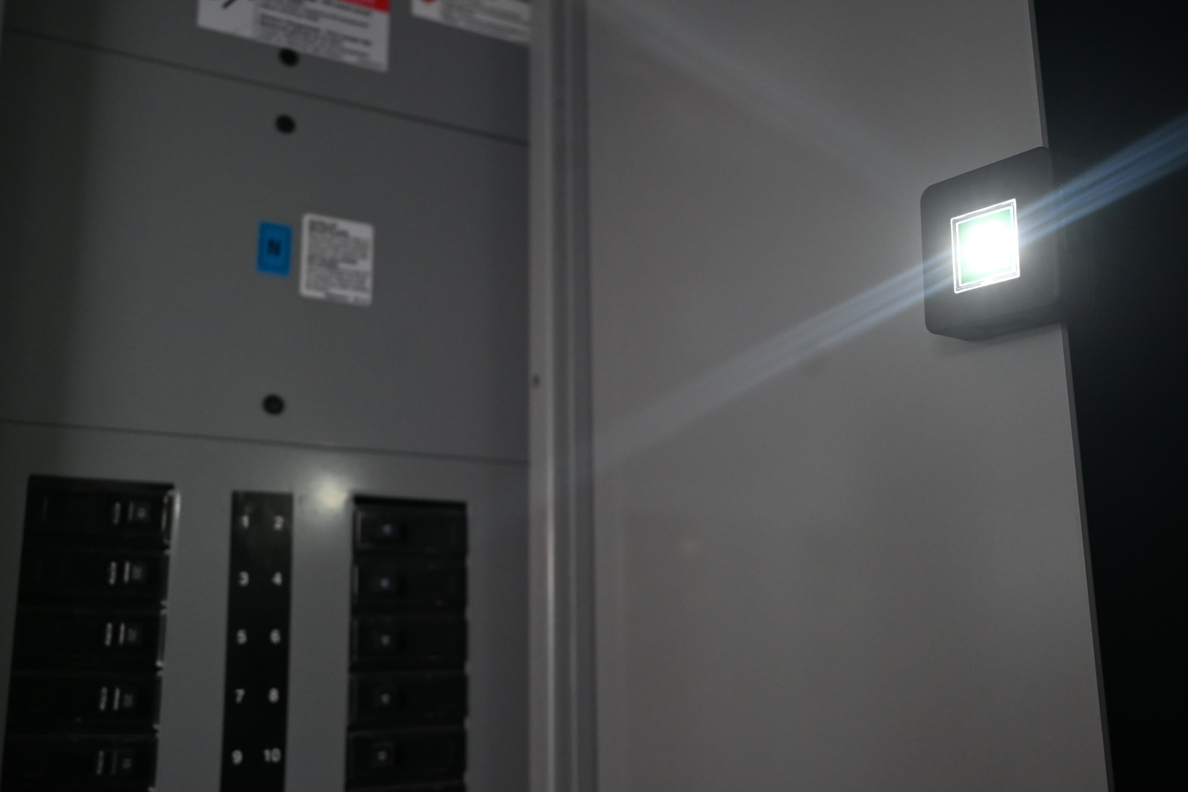 Maglight M1 magnetically attached to an electrical panel, beam cutting through the darkness